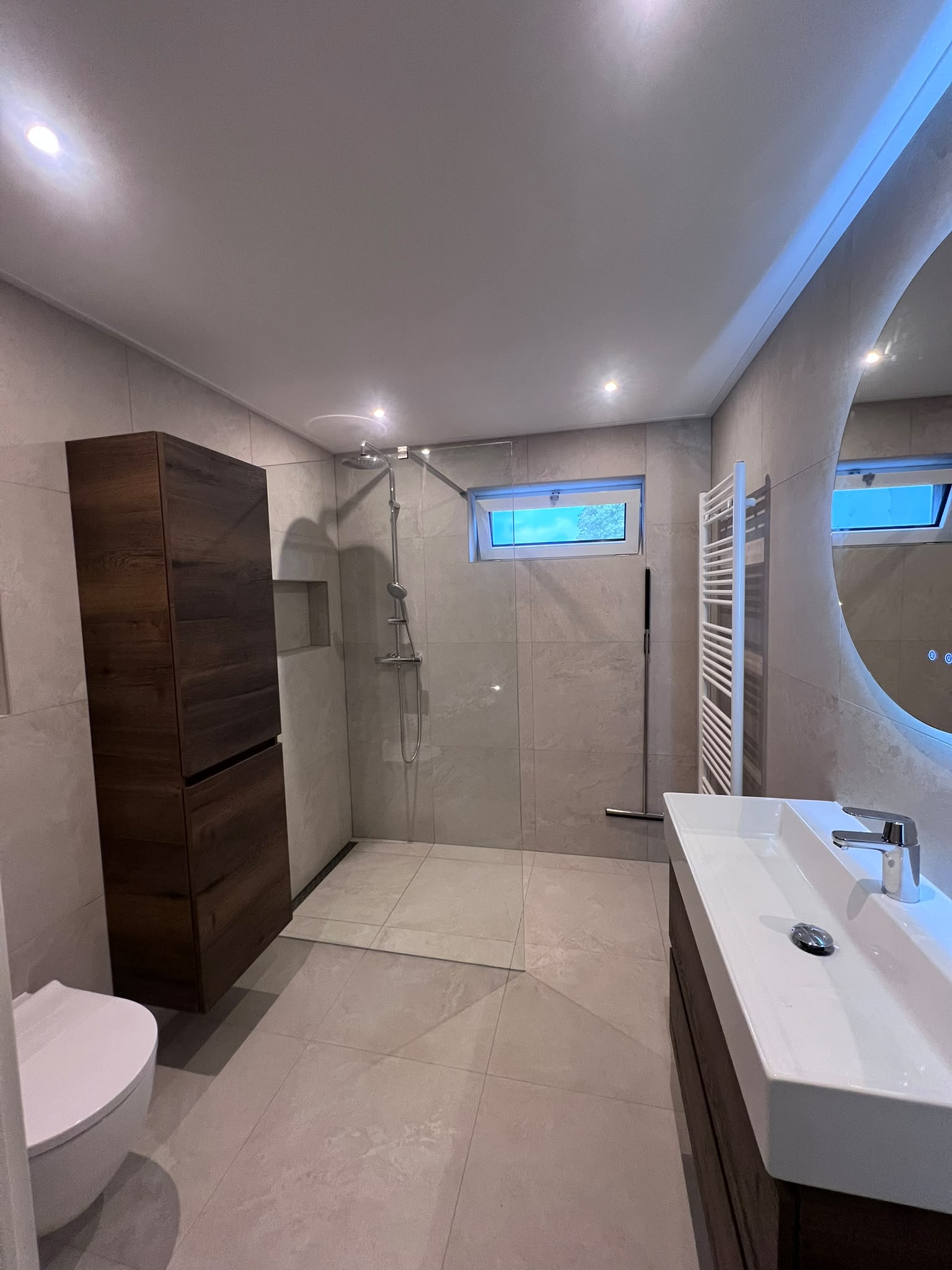 Badkamer van 5 m² met lichte tegels, hoge houtlook kast en wastafel