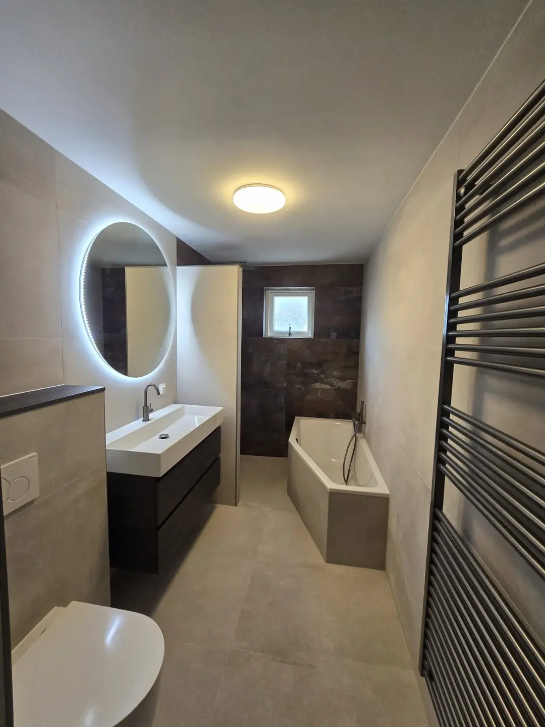Badkamer met ligbad en ovale spiegel — badkamerrenovatie in Nijmegen