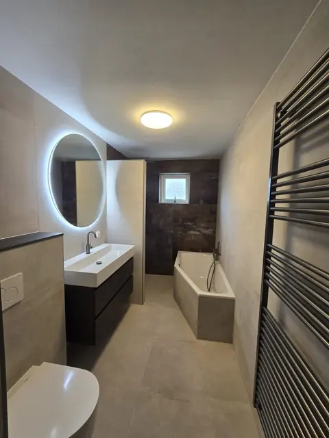 Badkamer met ligbad en ovale spiegel — badkamerrenovatie in Nijmegen