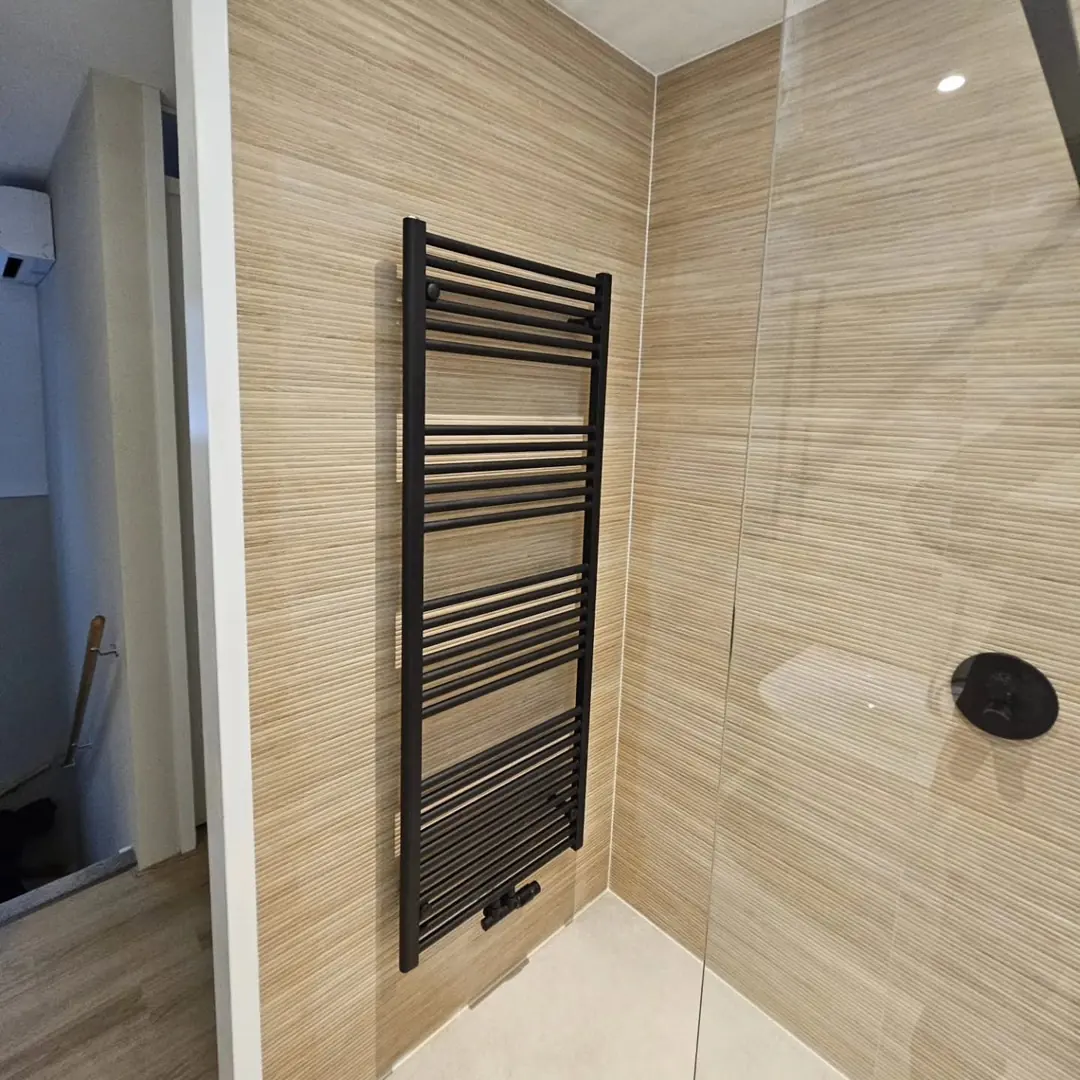 Zwarte designradiator tegen ribbelwand — badkamerrenovatie in Nijmegen