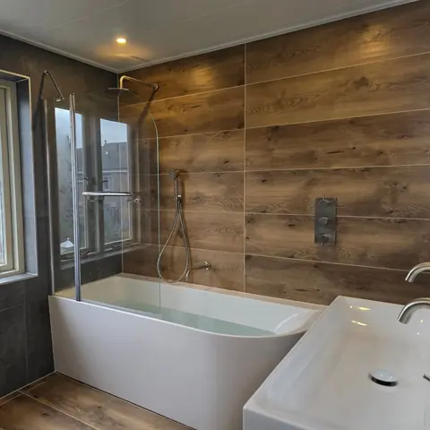 Badkamer met bad, douche en wastafel — badkamerrenovatie in Nijmegen