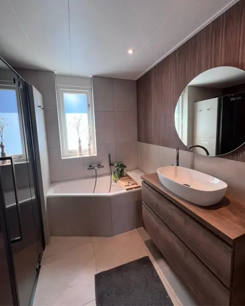 Hoekligbad met houten ribbelwand — badkamerrenovatie in Nijmegen