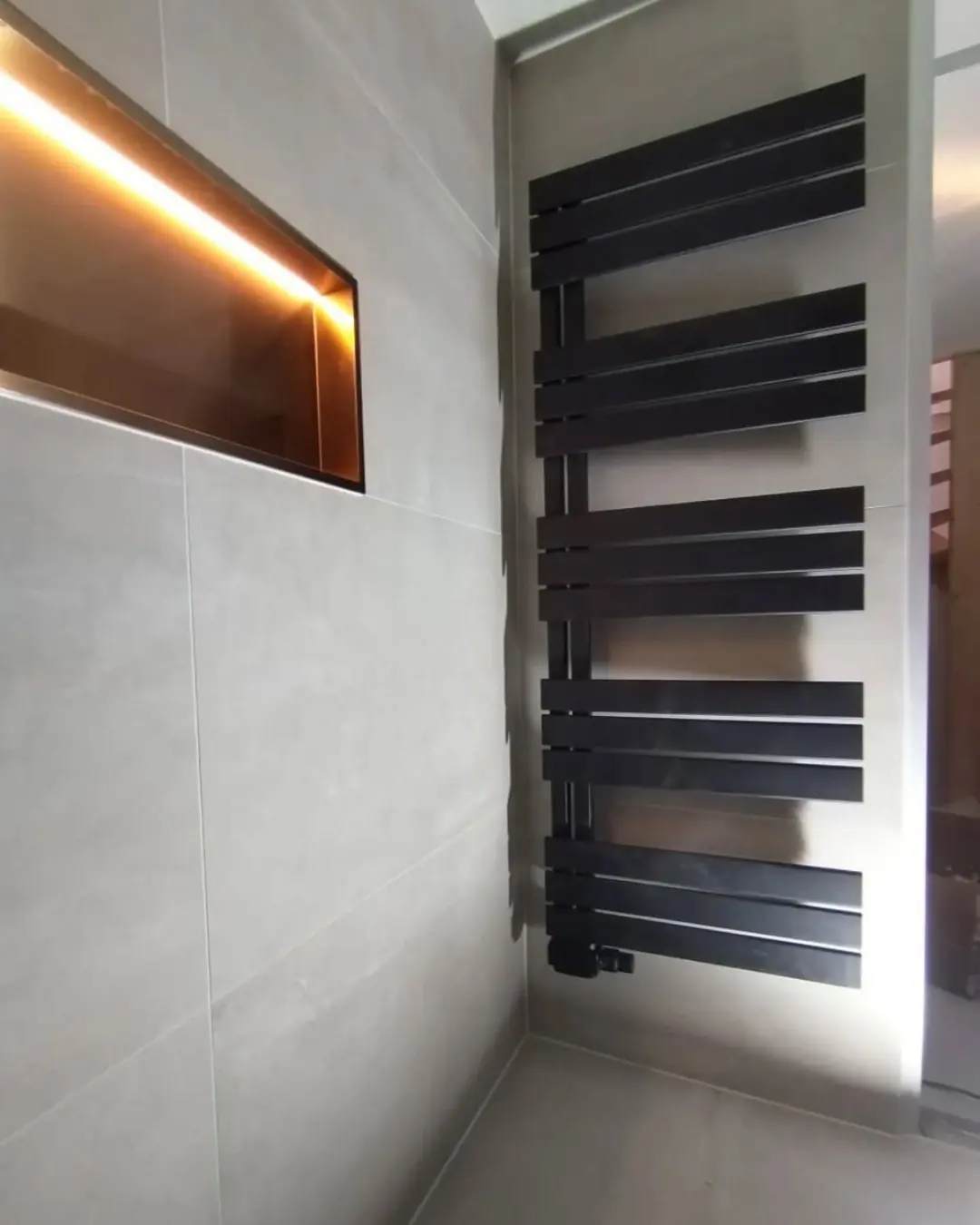 Verlichte nis met designradiator — badkamerrenovatie in Nijmegen