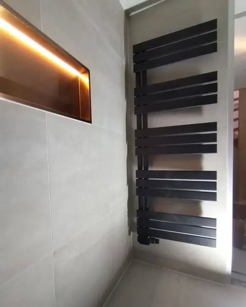 Verlichte nis met designradiator — badkamerrenovatie in Nijmegen